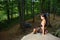 Female climber sitting on big natural boulder in the forest