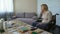 Female clinic patient sighs and looks at pills on the table, old age problems