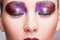 Female closed eye with evening violet eyes shadows, white eyelashes and purple lips makeup