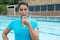 Female coach blowing whistle near poolside