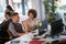 Female colleague explaining idea to a male colleague gesturing at desk in modern open space office. casual modern business concept