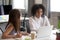 Female colleagues discuss ideas working at laptop together