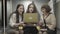 Female colleagues sitting together having break at work. Young and mature women chatting behind backs of co-workers