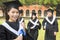 Female college graduate with classmates and holding a diploma