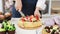 Female confectioner hands cutting appetizing fresh cake using knife. Close up shot on 4k RED camera