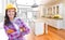 Female Construction Worker In Front of Custom Kitchen Drawing