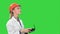 Female construction worker operating a crane using remote control on a Green Screen, Chroma Key.