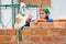 Female construction worker stacks terra cotta bricks to make wall at a construction site in Chiang Mai, Thailand