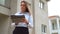 Female contractor in front of new building construction.