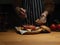 Female cook adding ketchup on fresh delicious bacon burger on wooden kitchen table