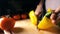 Female cook cutting whole yellow sweet pepper