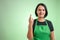Female cook with green apron and black t-shirt showing good luck