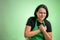 Female cook with green apron and black t-shirt suffering heart ache or breast pain, cardiac problems