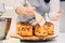 a female cook lubricates with melted butter a Kraffin, easter cake