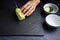 Female cook preparing some pieces of cucumber strips to make sushi on a blackboard