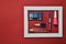 Female cosmetics in a white frame on a red background. Shadows for make-up, lipstick, nail polish, perfume bottle.