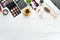 Female cosmetics on white office desk. Laptop, notepad, Lipstick, powder, comb, women`s jewelry. Top view.