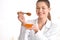 Female cosmetologist holding dipper and bowl with honey on blurred background