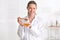 Female cosmetologist holding dipper and bowl with honey on blurred background