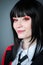 Female cosplayer with black hair, red eyes and a red jacket