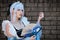 Female cosplayer in a vintage blue dress with blue hair