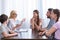 female counselor gesturing by hand and talking to family on therapy session