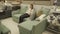 Female customer choosing sofa in shopping center. Woman sitting on couch imagining her new home architectural