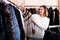 Female customer examining short coffee-colored fur jacket