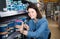 female customer examining various wall paints in paint store