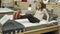 Female customer lies down on a new bed in a furniture store, choosing an orthopedic mattress to buy