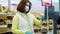 Female customer in medical mask weighing rye bread in supermarket