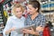 Female customer showing digital tablet to vendor in hardware store