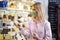 Female Customer Wearing Mask Shopping For Local Cheese In Delicatessen Food Shop During Health Pandemic