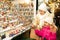 Female customers staring at counter of kiosk with figures for creating miniature Christmas scenes