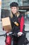 Female Cyclist With Cardboard Box And Courier Bag