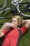 Female Cyclist Lying On Grass Drinking Water