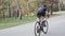Female cyclist sprinting out of the saddle. Cycling training concept. Uphill cycling ride. Slow motion