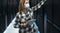 Female data center technician working inside server rack room while wearing facemask