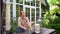 Female decorator decorates wooden table in garden with bouquet of dried flowers.