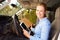 Female Delivery Driver Sitting In Van Using Digital Tablet