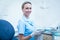 Female dentist in blue scrubs holding tray of tools