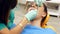 A female dentist checking a young woman`s teeth