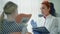 Female dentist with clipboard and patient woman at dental clinic office