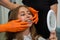 Female dentist conducts the initial examination with his hands touching his open mouth