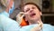 A female dentist examines the oral cavity of a patient with a dental mirror