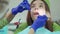 Female dentist examining patient teeth with dental tools. Medical treatment