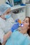 Female dentist fixed and dry dental fillings with light. Beautiful female dentist putting a filling on a tooth with caries of a