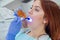 Female dentist fixed and dry dental fillings with light. Beautiful female dentist putting a filling on a tooth with caries of a