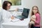 Female dentist orthodontist with x-ray talking to a child.