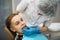 Female dentist puts on a guy patient a mouth guard in dental clinic.
